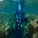 Divers glide through the Silfra tectonic fissure. Located between the North American and Eurasia tectonic plates in Iceland's Thingvallavatn National Park, this exotic dive site offers stunning geology and the clearest and most pristine water on the planet, with visibility limited only by the clarity of a diver's mask.									